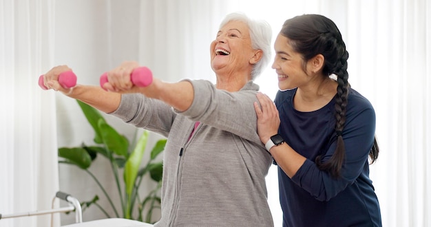 Ältere glückliche Hantel- oder Physiotherapeutin-Beratungsdienst und Ruhestandsunterstützung bei der Genesungsrehabilitation Physiotherapie-Heilarmübung oder Person, die alten Patienten beim Training hilft