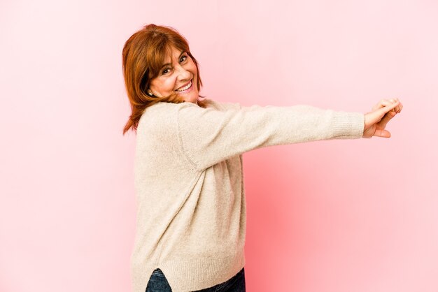 Ältere kaukasische Frau isolierte streckende Arme, entspannte Position.