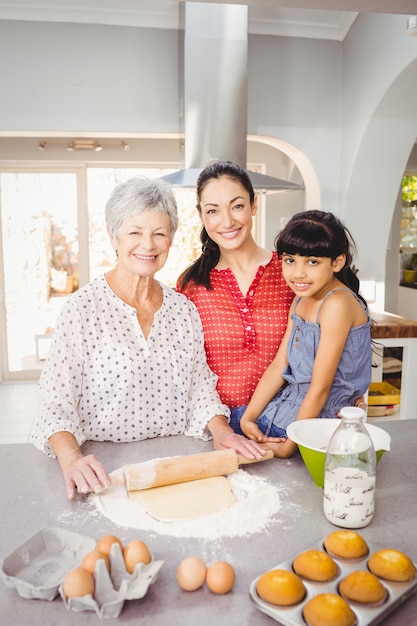 Ältere lächelnde Frau beim Zubereiten des Lebensmittels mit Familie