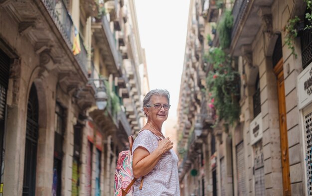 Ältere lächelnde Frau reist nach Barcelona und besucht die Altstadt, um die Feiertage zu genießen