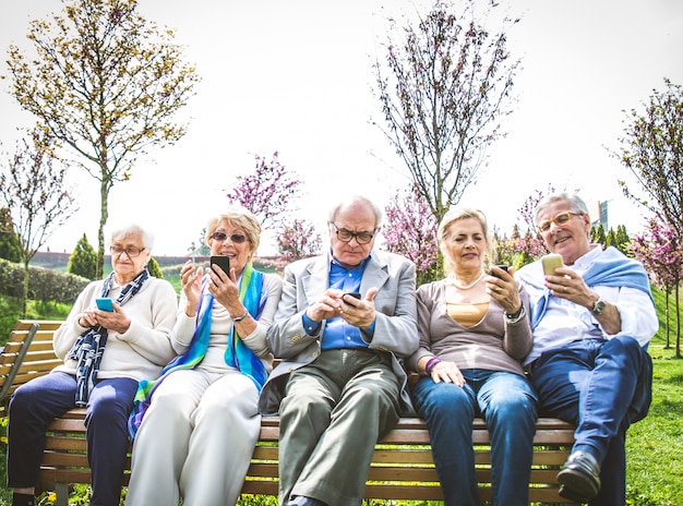 Ältere Leute, die Smartphones schauen