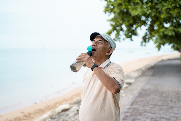 Ältere männliche asiatische Trinkwasserflasche