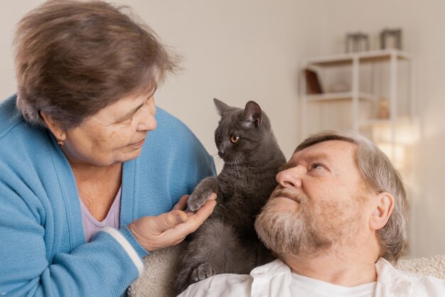 Ältere Menschen kümmern sich um Katzen und genießen sie zu Hause