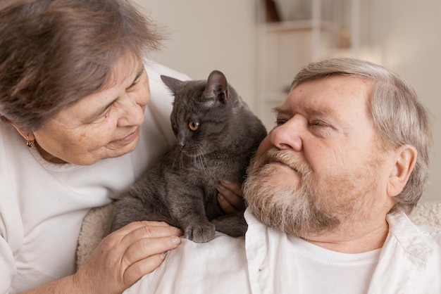 Ältere Menschen kümmern sich um Katzen und genießen sie zu Hause
