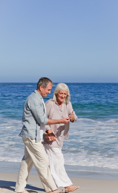 Ältere Paare, die auf den Strand gehen