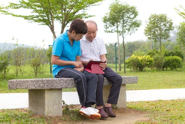 Ältere Paare, die das mobile Tablet betrachten