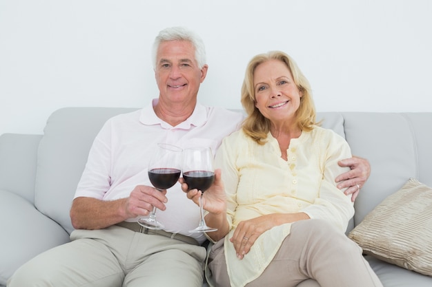 Ältere Paare, die zu Hause Weingläser rösten
