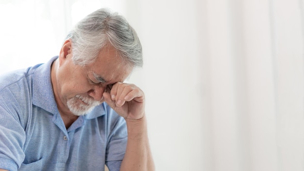 Ältere Patienten im Bett Asiatische Seniorenpatienten Kopfschmerzen Hände auf der Stirn Medizin- und Gesundheitskonzept