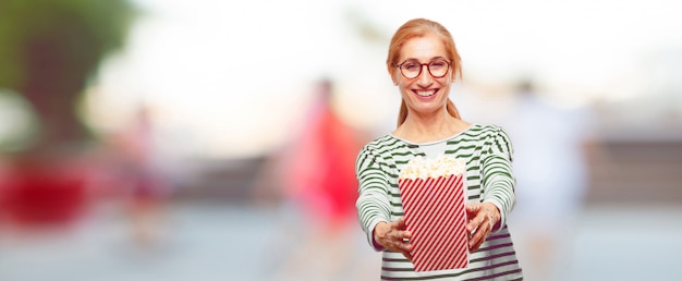 Ältere Schönheit mit einem Popcorneimer