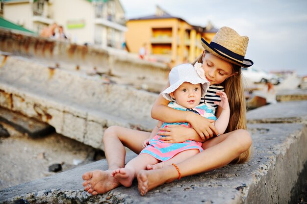 Ältere Schwester, die ihre jüngere Schwester umarmt