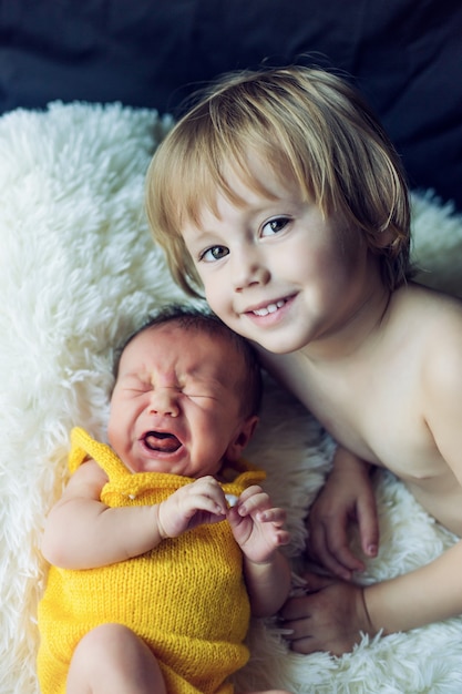 Ältere Schwester mit ihrem neugeborenen Bruder