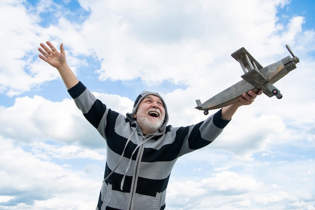 Ältere Senior Mann am Himmel Hintergrund Senior Mann im Ruhestand Senior Mann im Ruhestand mit Spielzeugflugzeug