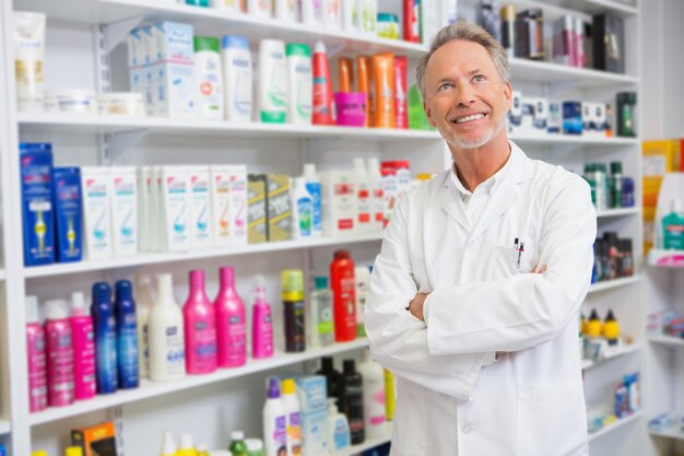 Älterer Apotheker, der oben in der Apotheke lächelt und schaut