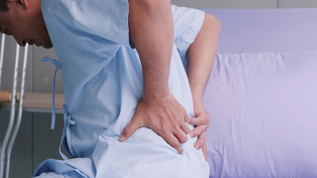 Älterer asiatischer männlicher Patient wird mit Rückenschmerzen ins Krankenhaus eingeliefert