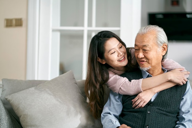 Älterer asiatischer Vater und erwachsene Tochter unterhalten sich zu Hause