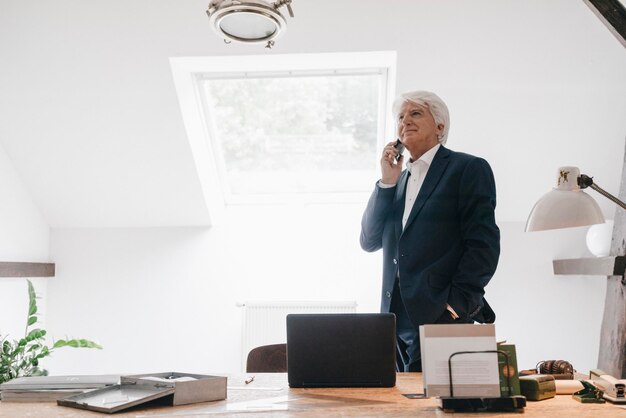 Älterer Geschäftsmann am Telefon in seinem Büro