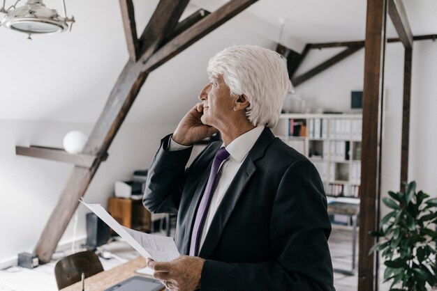 Älterer Geschäftsmann am Telefon in seinem Büro