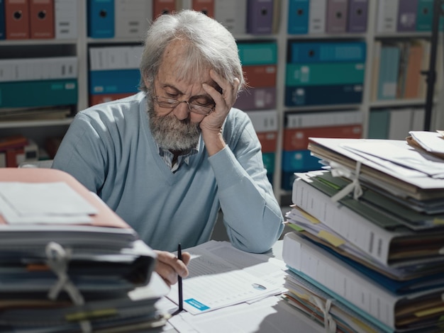 Älterer Geschäftsmann, der im Büro arbeitet