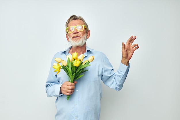 Älterer grauhaariger Mann ein Blumenstrauß mit Brille als Geschenk heller Hintergrund