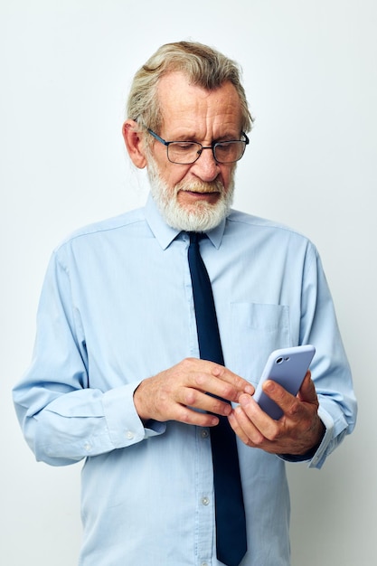 Älterer grauhaariger Mann in einem Hemd mit Krawatte, der am Telefon telefoniert, beschnittene Ansicht