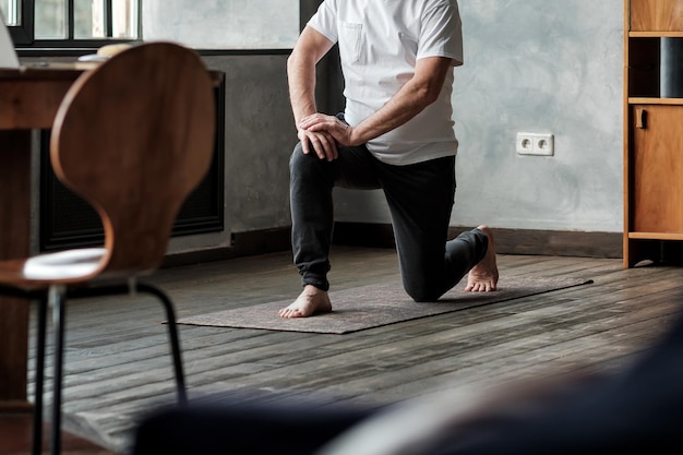 Älterer hispanischer Mann, der in Krieger-Yoga-Pose-Variation steht