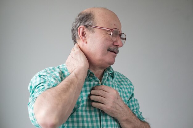 Älterer hispanischer Mann hat Schmerzen im Nacken