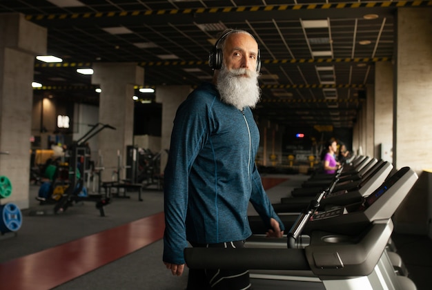 Älterer Mann auf laufender Maschine im Fitnessstudio