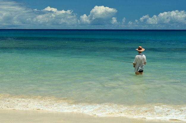 Älterer Mann beim Angeln im Meer mit einer Angelrute