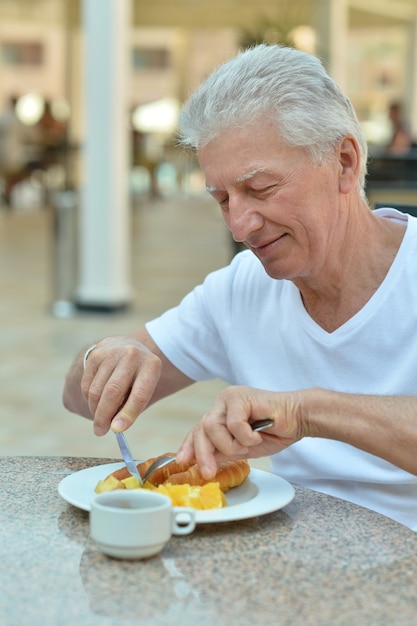 Älterer Mann beim Frühstück in einem Café