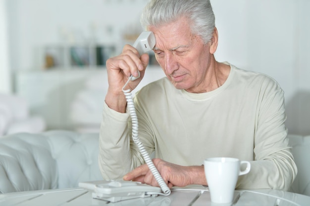 Älterer Mann, der am Telefon spricht