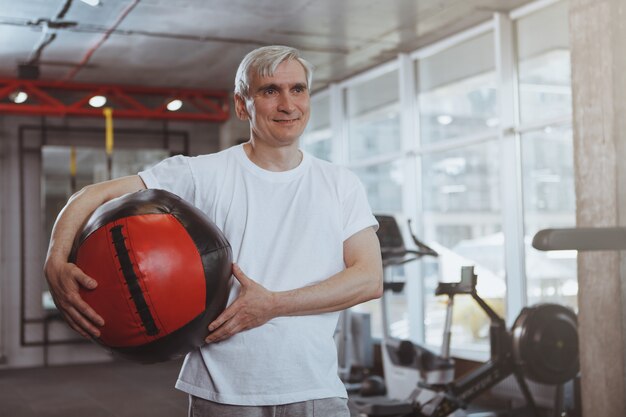 Älterer Mann, der an der Turnhalle ausarbeitet