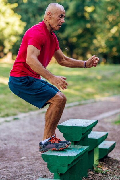 Älterer Mann, der draußen im allgemeinen Park trainiert