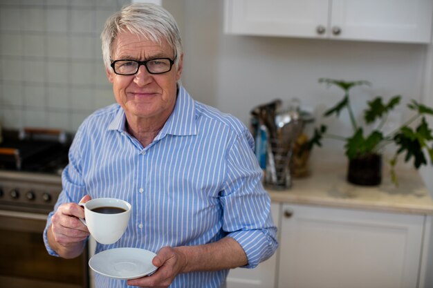 Älterer Mann, der eine Tasse Kaffee hält