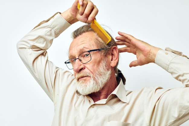 Älterer Mann, der Haare im Studio kämmt