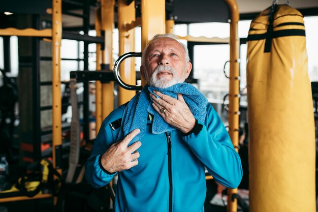 Älterer Mann, der im Fitnessstudio trainiert.