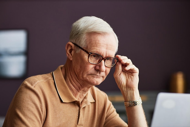 Älterer Mann, der online am Laptop arbeitet