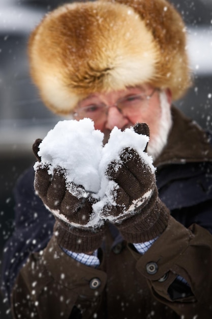 Älterer Mann, der Schneeball, Fokus auf Vordergrund hält