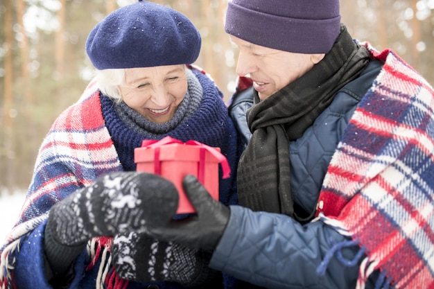 Älterer Mann, der seiner Frau ein Geschenk gibt