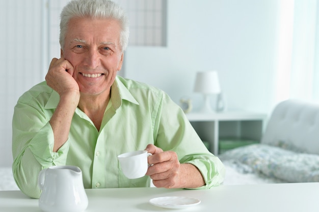 Älterer Mann, der zu Hause eine Tasse Kaffee trinkt