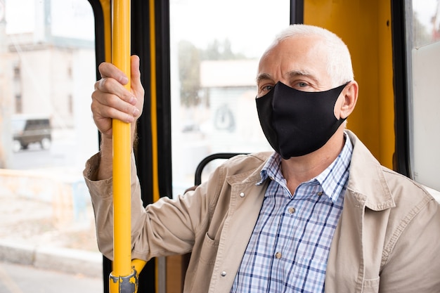 Älterer Mann mit medizinischer Maske im öffentlichen Verkehr. Virus Schutz