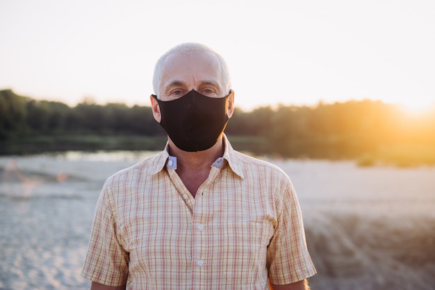 Älterer Mann trägt Schutzmaske gegen Infektionskrankheiten und Grippe, Gesundheitskonzept. Coronavirus Quarantäne.