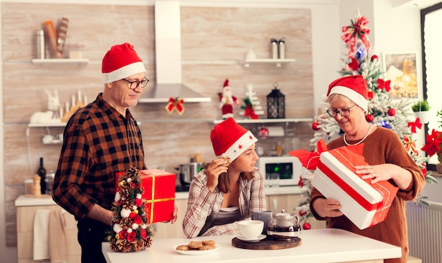 Älterer Mann und Frau, die Weihnachten mit Enkelkind feiern