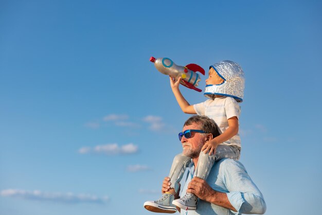 Älterer Mann und Kind im Freien vor Sommerhimmelhintergrund. Großvater und Junge haben gemeinsam Spaß. Familienurlaubskonzept. Alles gute zum Vatertag