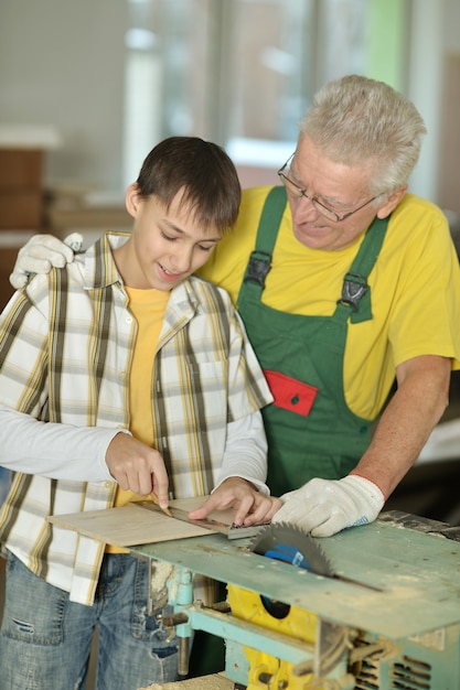 Älterer Mann und sein Enkel reparieren im Zimmer