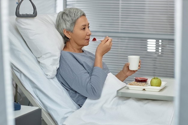 Älterer Patient isst gesundes Essen auf der Station