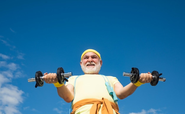 Älterer Sportler trainieren Senioren, die Hanteln heben