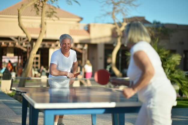 Älteres Ehepaar spielt Tischtennis im Hotelhof