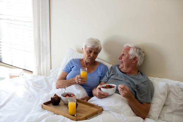 Älteres Paar beim Frühstück im Schlafzimmer zu Hause