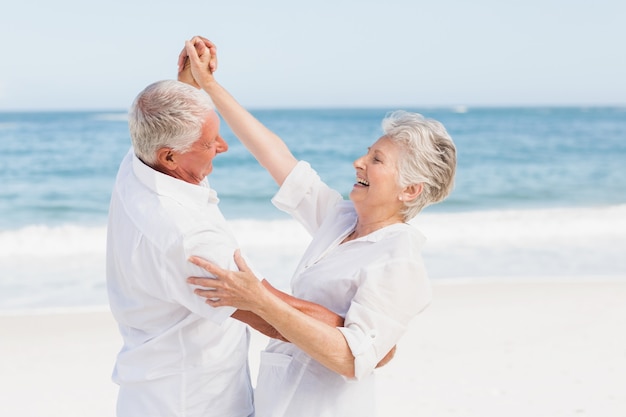 Älteres Paar, das am Strand tanzt