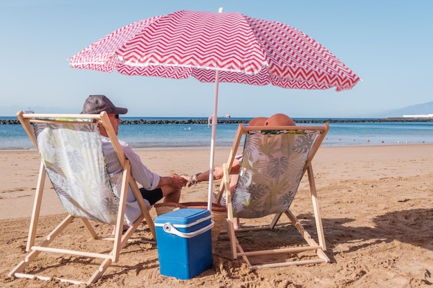 Älteres Paar, das auf dem Liegestuhl sitzt, sich sonnen und ausruhen Konzept Ruhe Trennung Strand